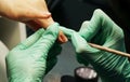 Manicurist applying polish on client's nails at table, closeup Royalty Free Stock Photo