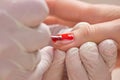 Manicurist applying red nail varnish. Royalty Free Stock Photo