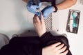 A manicurist in a black face mask makes and blue gloves manicure for a client using an electric nail file. Female hardware Royalty Free Stock Photo