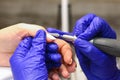 A manicurist in blue gloves gives a manicure