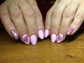 The manicurist excellently made her work a beautiful manicure with a polish gel on her hands and the client is happy