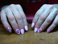 The manicurist excellently made her work a beautiful manicure with a polish gel on her hands and the client is happy