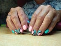 The manicurist excellently made her work a beautiful manicure with a polish gel on her hands and the client is happy