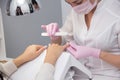 A manicurist gives a manicure to a client. Portrait of an attractive nail salon worker giving a manicure to one of her