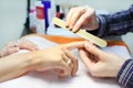 Manicurist hands make manicure by nailfile Royalty Free Stock Photo