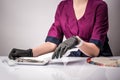 Manicurist holding in her hands gloved accessories for manicure and pedicure on a white background. Nails manicure detail in