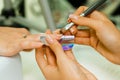 Manicurist makes escalating of nails. Use the nail file makes nail shape. Hands shot close-up on a light background Royalty Free Stock Photo