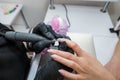 A manicurist makes a hardware manicure to a client of a beauty salon. The process of removing the cuticle cutter close-up