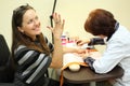 Manicurist makes manicure for woman by nail polish