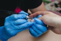 The manicurist makes the processing of the client`s cuticle by hardware, close-up