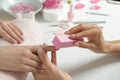 Manicurist polishing client`s nails with buffer at table, closeup
