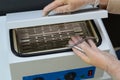 Manicurist prepare nail nipper for hot air sterilization in autoclave