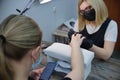 The manicurist processes the nail plate, preparing it for the gel polish coating