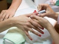 Manicurist putting red nail polish