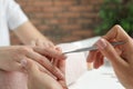 Manicurist removing cuticle from client`s nails with pusher. Spa treatment Royalty Free Stock Photo