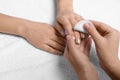 Manicurist removing polish from client`s nails on white, closeup Royalty Free Stock Photo