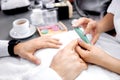 Manicurist rounding the edges using nail file Royalty Free Stock Photo