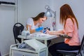 Manicurist treating client at beauty salon - painting on the nail Royalty Free Stock Photo