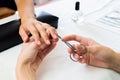 Manicurist trimming a clients cuticles Royalty Free Stock Photo