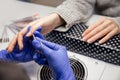 Manicurist uses scissors tool to cut cuticle on nails of client girl Royalty Free Stock Photo