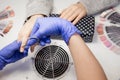 Manicurist uses scissors tool to cut cuticle on nails of client girl Royalty Free Stock Photo