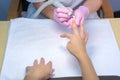 Manicurist woman removes shellac polish using manicure machine, hands closeup.