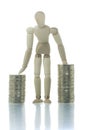 Manikin standing between two coin piles