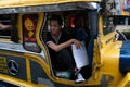 MANILA, PHILIPPINES - JANUARY 25,2012: Man sits jeepney rolling