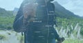 Manipulating floating data hologram, hiker in dark jacket on mountain trail with backpack and poles Royalty Free Stock Photo