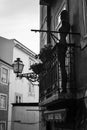 Maniqin on the balcony. Old Lisbon street photo. Portugal. B&W Black and white. Old town. building. Windows. Emotions. Lantern.
