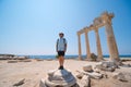 A manl in hat and sunglasses poses with a view of the ruins of the ancient Roman temple of Apolon. Side, Turkey Royalty Free Stock Photo