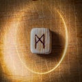 Mannaz. Handmade scandinavian wooden runes on a wooden vintage background in a circle of light. Concept of fortune