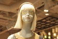 Mannequin blonde in women`s clothing store. Dummy with funny eyelashes. Fashion industry concept. Window clearance
