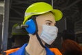 Mannequin Builder in a protective mask from coronavirus yellow helmet headphones. Construction, medicine