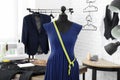 Mannequin with custom tailored dress and measuring tape in atelier