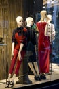 Mannequin dolls in summerr outfit displayed n the shop window of Max Mara clothing expensive and elegant brand with city lights