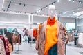 Mannequin dressed in a bright warm orange sweater, plaid jacket casual wear in a mall store. Female mannequins in a shop