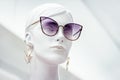 Mannequin face. Bright portrait of female beautiful dummy in purple sunglasses with earrings on isolated white background Royalty Free Stock Photo