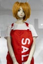 mannequin girl in a seller& x27;s apron with red hair in a clothing store Royalty Free Stock Photo