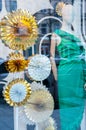 A mannequin in a green dress in a New Year\'s showcase with gold large circles