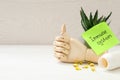 Mannequin hand, pills and note with phrase Immune System on white wooden table. Space for text Royalty Free Stock Photo