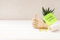 Mannequin hand, pills and note with phrase Immune System on white wooden table. Space for text Royalty Free Stock Photo