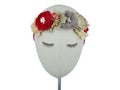 Mannequin head wearing hair accessory made out of fabric flowers in red and beige colors