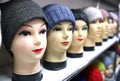 Mannequin heads in knitted hats and scarves. Mannequins female heads in hats and scarfs close up. Woolen knitted caps Royalty Free Stock Photo