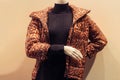 mannequin in a shop window wearing a black turtleneck and a leopard print jacket