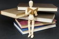 Mannequin sitting on a mountain of reading books Royalty Free Stock Photo