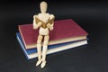 Mannequin sitting on two books reading Royalty Free Stock Photo