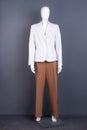 Mannequin in white blazer and brown trousers.