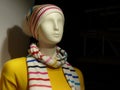 Mannequin with a yellow blouse and a striped hat and scarf Royalty Free Stock Photo