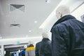 Mannequins stand in a row in the store and are dressed in different clothes. Bottom-up view of the ceiling Royalty Free Stock Photo